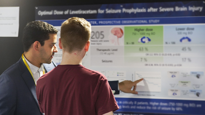 Attendees viewing science abstract posters at the Autoimmune Neurology Conference.