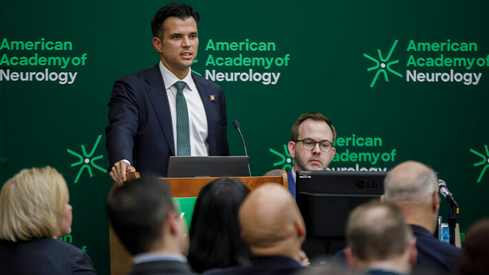 Attendee speaking behind a podium during an Annual Meeting program