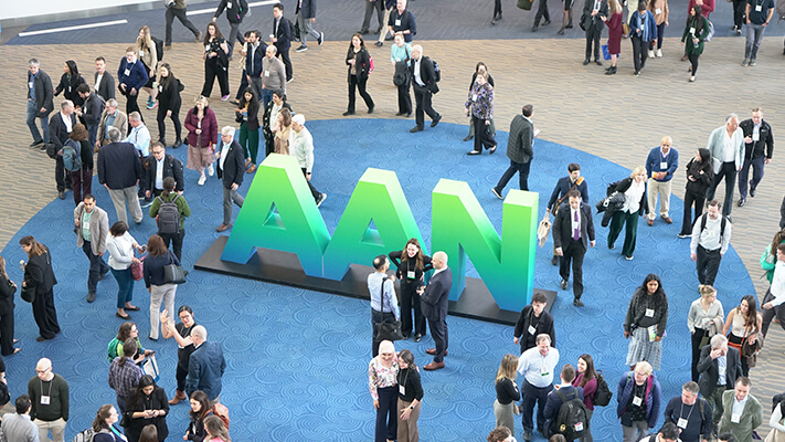 Busy conference hallway overhead view with AAN letters statue in center