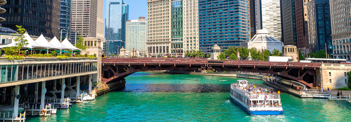 A boat traveling down the river in downtown Chicago