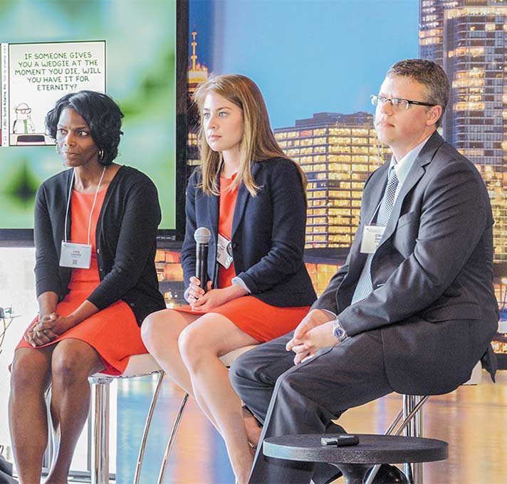 Two women, one man sit on panel listening to a question