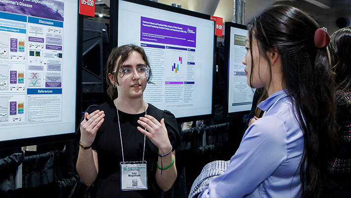 Female poster Presenting to person in front of digital display