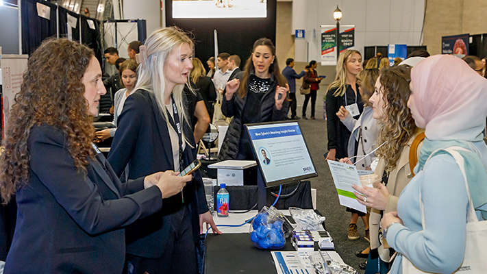 Participants and exhibitors engage in lively conversation.